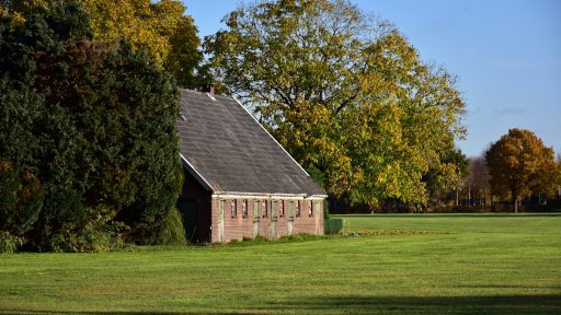 a small building sitting in the middle of a field