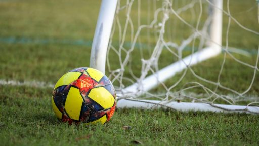 red blue and yellow soccer ball on green grass field