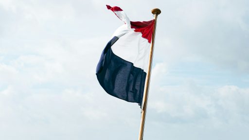 flag of us a on pole under white clouds