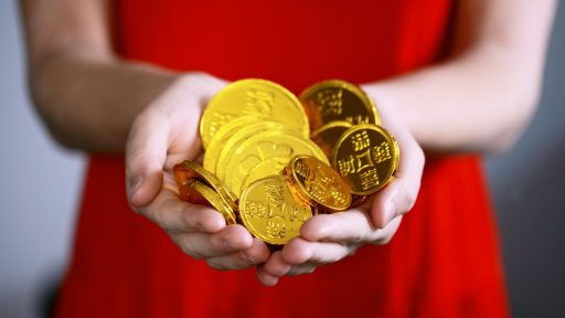 person holding gold-colored ching coins