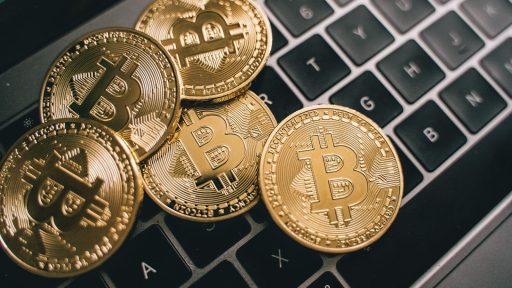 Close-up of multiple Bitcoin coins on a laptop keyboard symbolizing digital currency and cryptocurrency trading.