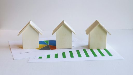 three small houses sitting on top of a piece of paper
