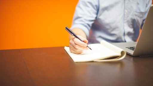 Zzp'er werkt achter laptop aan bureau en bekijkt financiële documenten