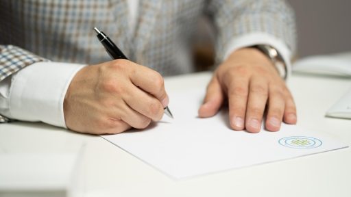 Persoon die een leasecontract tekent bij een autodealer