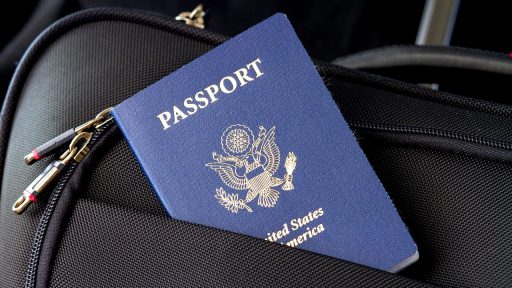 Paspoort en reisdocumenten naast een koffer, klaar voor een vakantie die mogelijk geannuleerd wordt