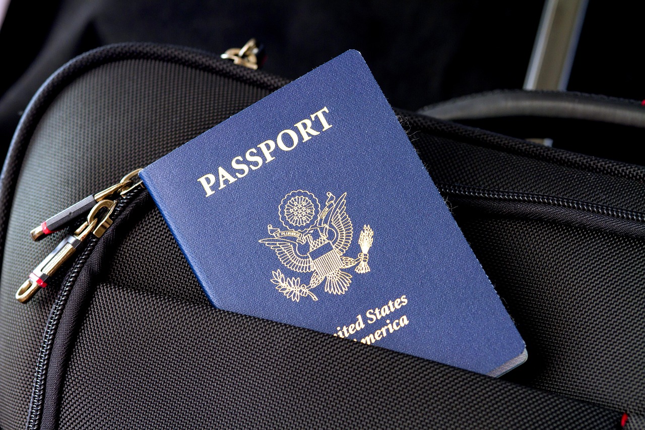 Paspoort en reisdocumenten naast een koffer, klaar voor een vakantie die mogelijk geannuleerd wordt
