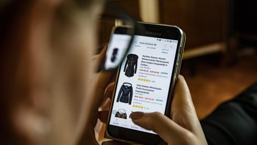 Vrouw die kleding bekijkt op een laptop tijdens online winkelen