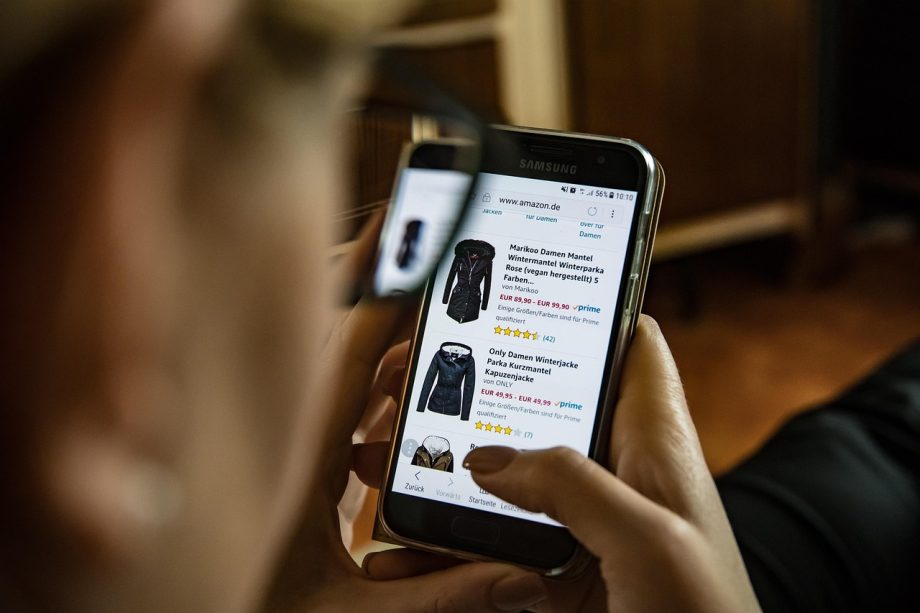 Vrouw die kleding bekijkt op een laptop tijdens online winkelen