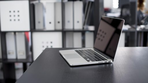 Persoon die een cryptoportefeuille bekijkt op een laptop aan een bureau