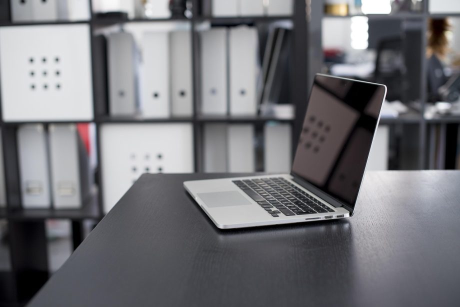 Persoon die een cryptoportefeuille bekijkt op een laptop aan een bureau
