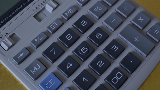 Zzp'er die thuis zijn financiën berekent met pen en papier aan een bureau