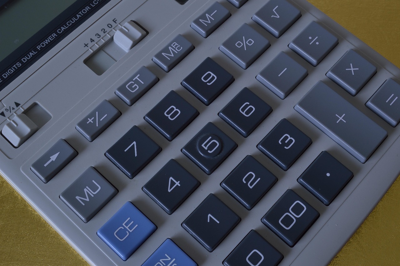 Zzp'er die thuis zijn financiën berekent met pen en papier aan een bureau