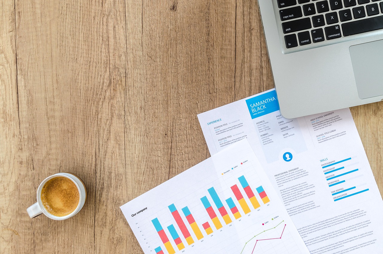 Persoon die financiële grafieken analyseert op een laptop