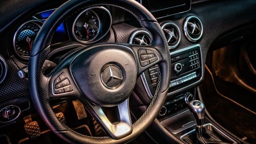 Dashboard van een auto met een rekenmachine op de voorgrond, symbool voor het berekenen van autokosten