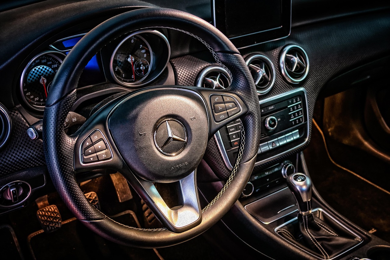 Dashboard van een auto met een rekenmachine op de voorgrond, symbool voor het berekenen van autokosten