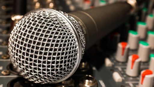 Presentator met microfoon in een tv-studio, symbool voor inkomsten uit televisie en entertainment