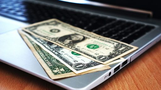 Freelance muzikant die zijn financiën bijhoudt aan een bureau met facturen en een laptop