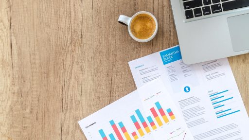 Persoon die financiële documenten doorneemt aan een bureau ter voorbereiding op het jaareinde