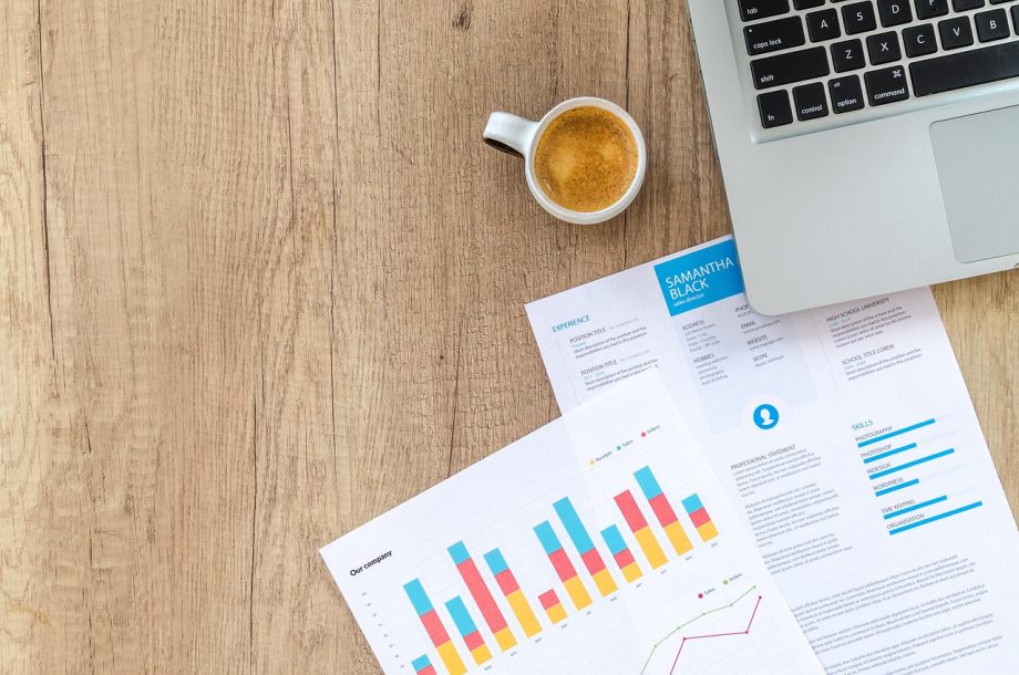 Persoon die financiële documenten doorneemt aan een bureau ter voorbereiding op het jaareinde