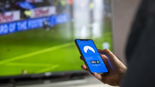 Persoon die een beleggingsapp bekijkt op een smartphone aan een bureau