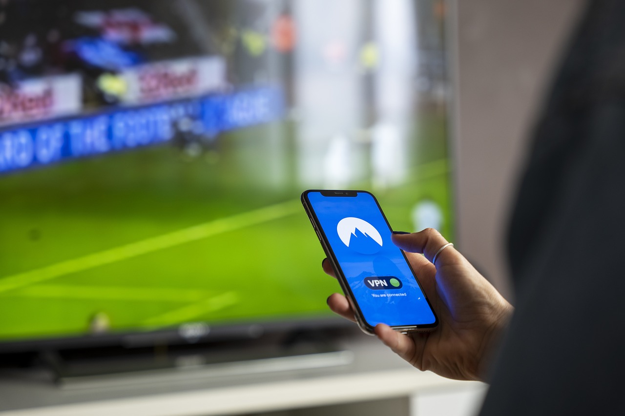 Persoon die een beleggingsapp bekijkt op een smartphone aan een bureau