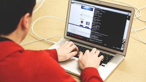 Zzp'er werkt aan laptop aan keukentafel en vergelijkt AOV-opties