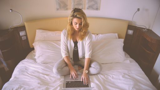 Persoon die internationaal arbeidscontract en hypotheekaanvraag bekijkt op laptop