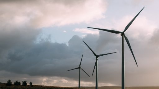 Windmolens naast hoogspanningslijnen in een open landschap