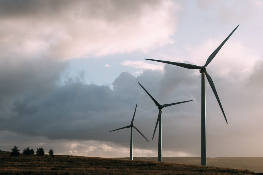 Windmolens naast hoogspanningslijnen in een open landschap
